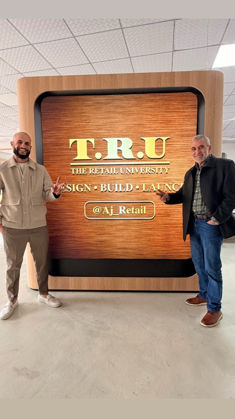 Anwar AJ Asmar beside The Retail University sign — Design, Build, Launch